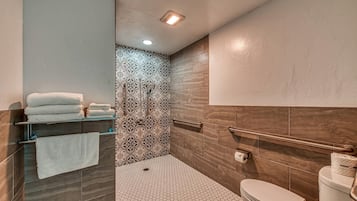 Un baño moderno con ducha, inodoro y toallero.