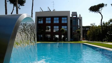 Una piscina al aire libre, sillones reclinables de piscina