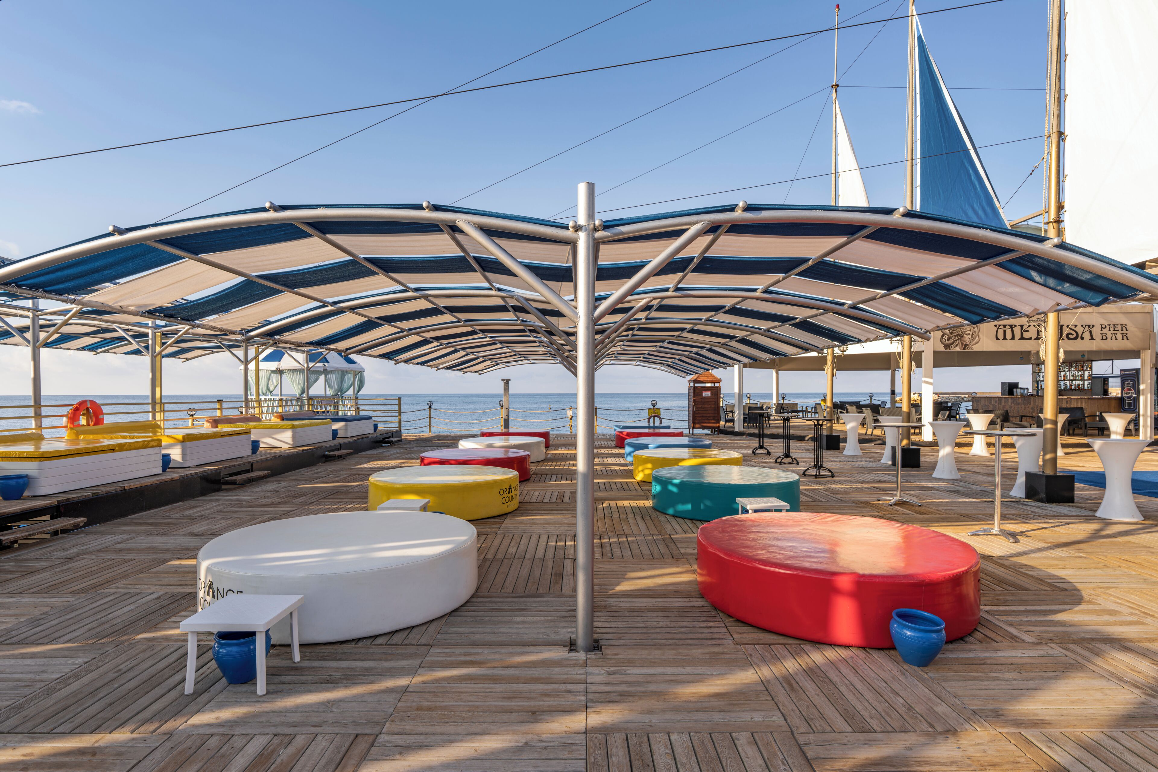 A deck with colorful seating, a bar, and a lifebuoy.