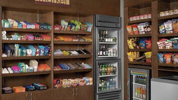 A grocery store with multiple shelves stocked with various products including snacks, beverages, and household items.