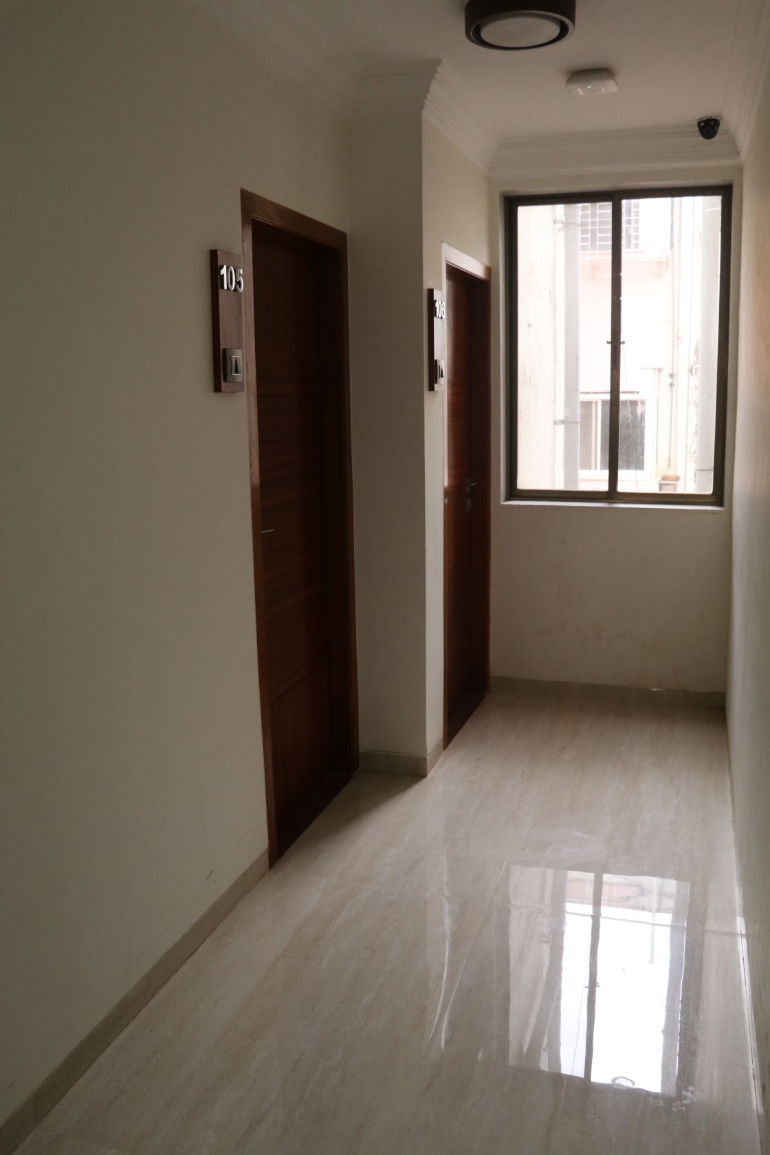 A hallway with two wooden doors, each marked with a number.
