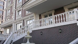 A multi-story building with a central fountain, a staircase, and a brick facade. - KievRent Apartments (Kyiv)