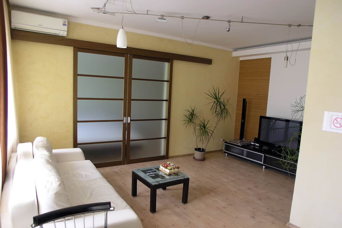 A living room with a sofa, a coffee table, a TV, and a sliding door.