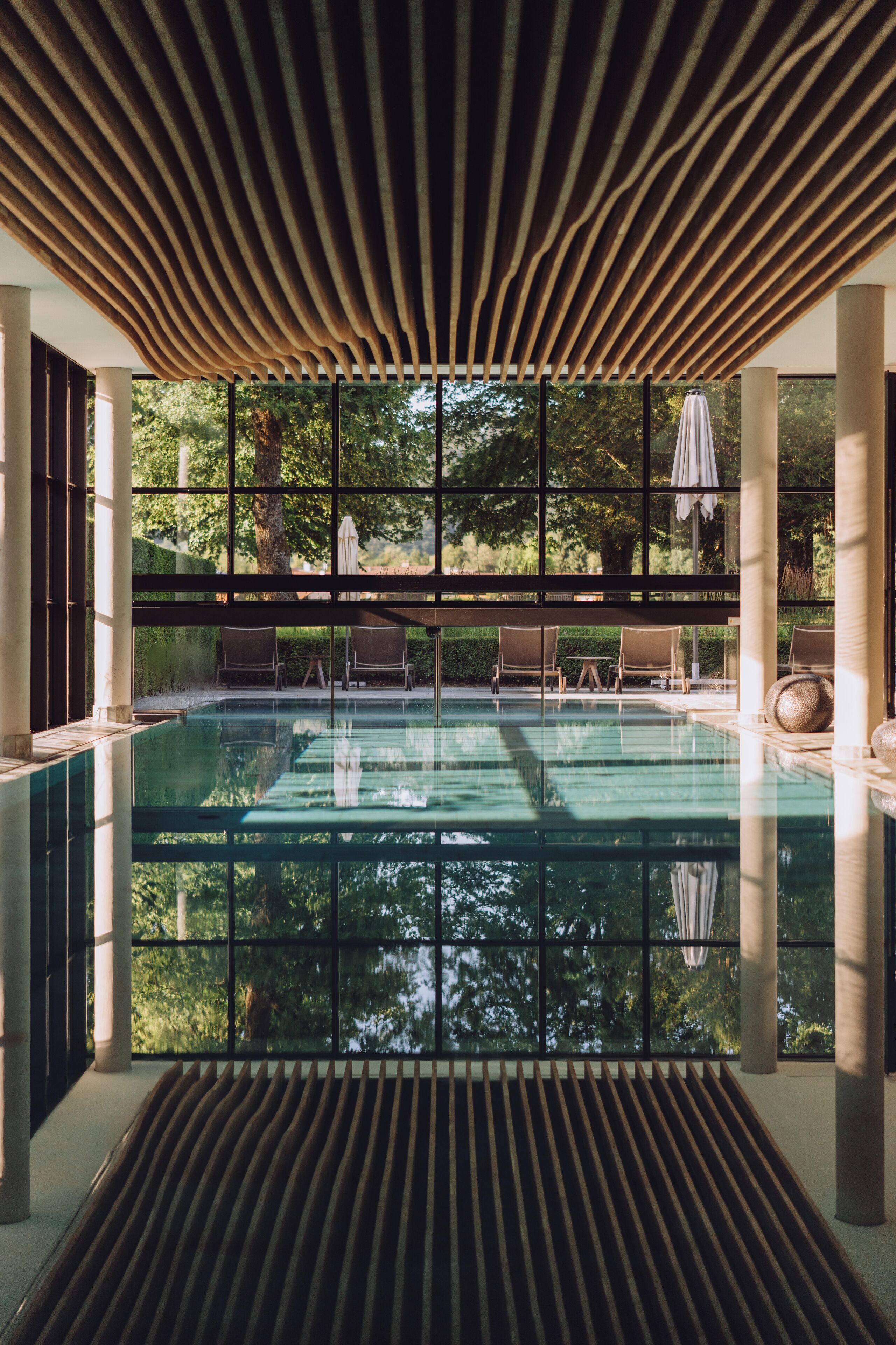 Una piscina techada, sillones reclinables de piscina