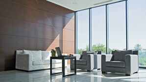 A modern living room with a large window, a sofa, two armchairs, and a coffee table. - Hotel Sercotel JC1 Murcia (Murcia)