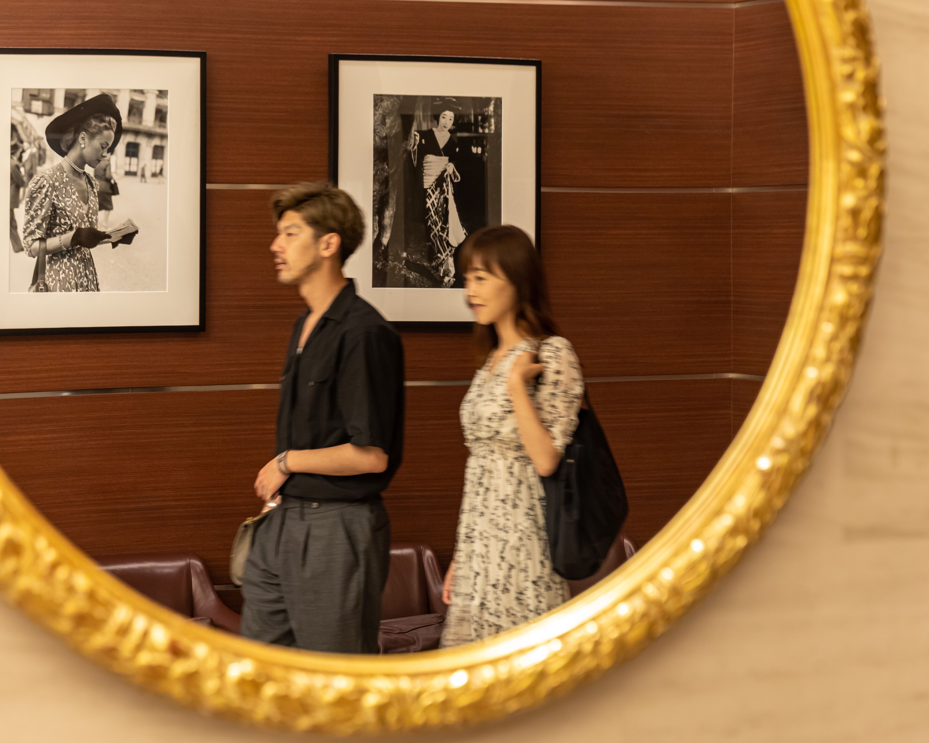 A room with wooden panel walls and a large mirror with a golden frame.