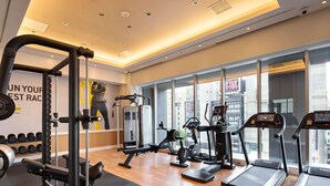 Een sportschool met loopbanden, krachttrainingsapparaten en gewichten.
