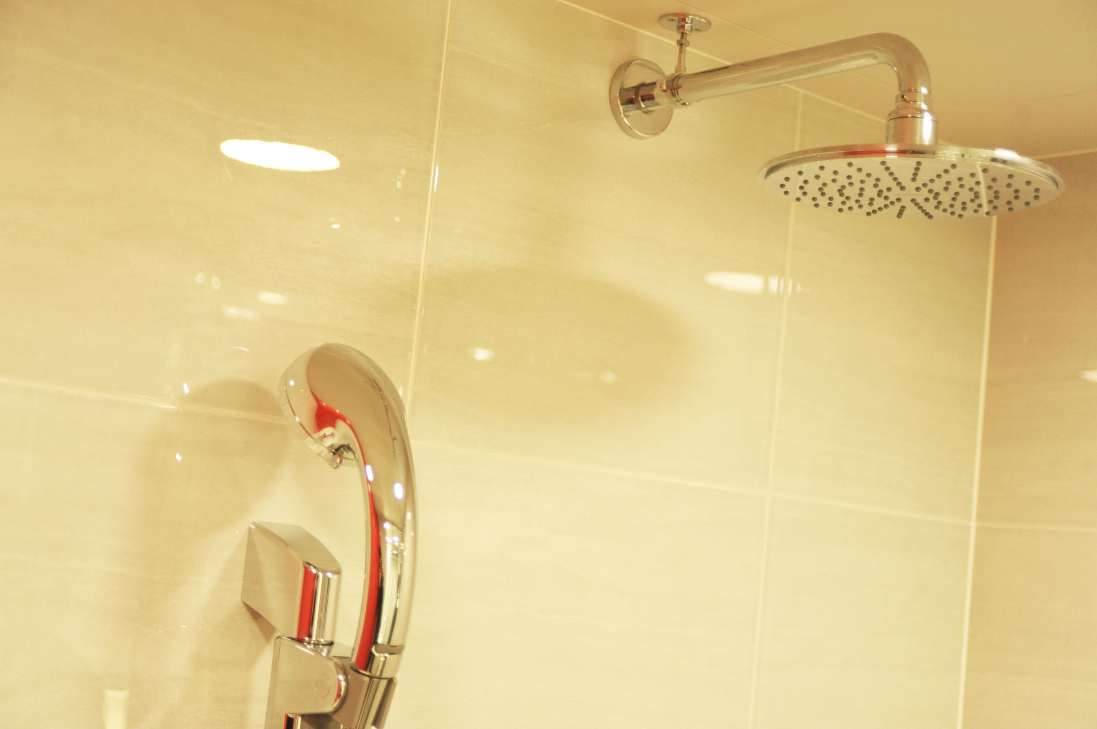 Une salle de bain moderne avec une douche et un miroir.