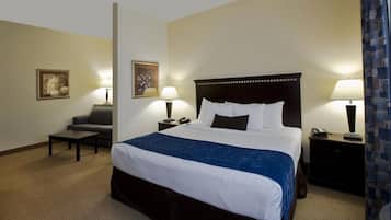 A hotel room with a large bed, two bedside tables, a chair, and two lamps.