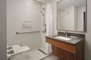 Ein modernes Badezimmer mit Dusche, Toilette, Waschbecken und Spiegel.