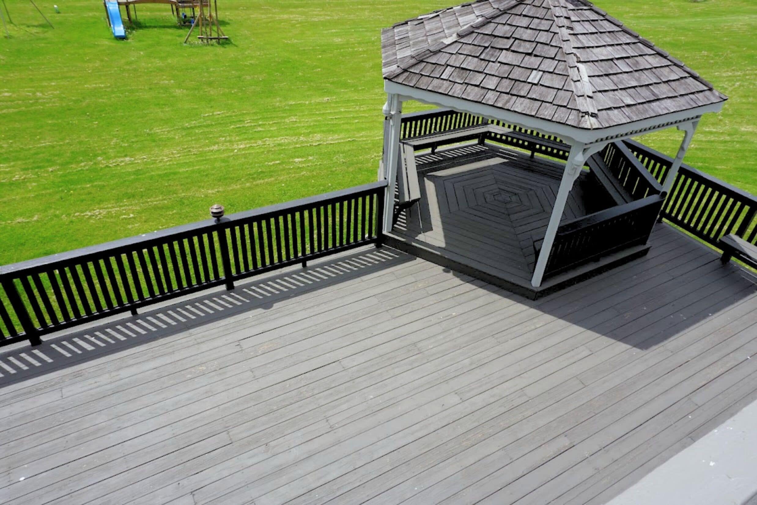 A wooden deck with a gazebo structure.