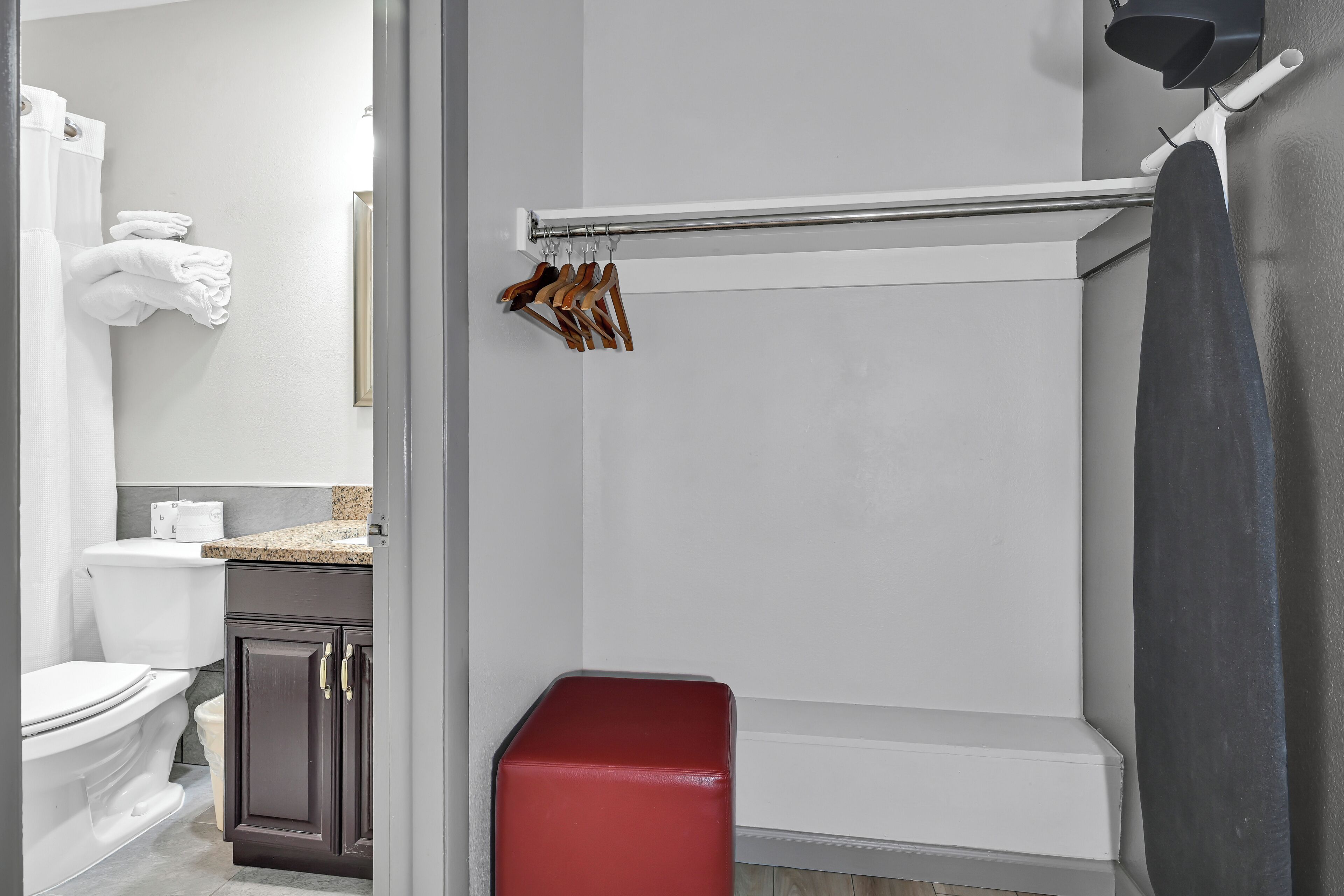Une salle de bain comprenant des toilettes, un lavabo, un miroir, un porte-serviettes avec des serviettes et un espace douche.