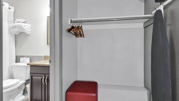 Une salle de bain comprenant des toilettes, un lavabo, un miroir, un porte-serviettes avec des serviettes et un espace douche.