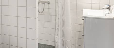 A bathroom with a shower, toilet, and sink.
