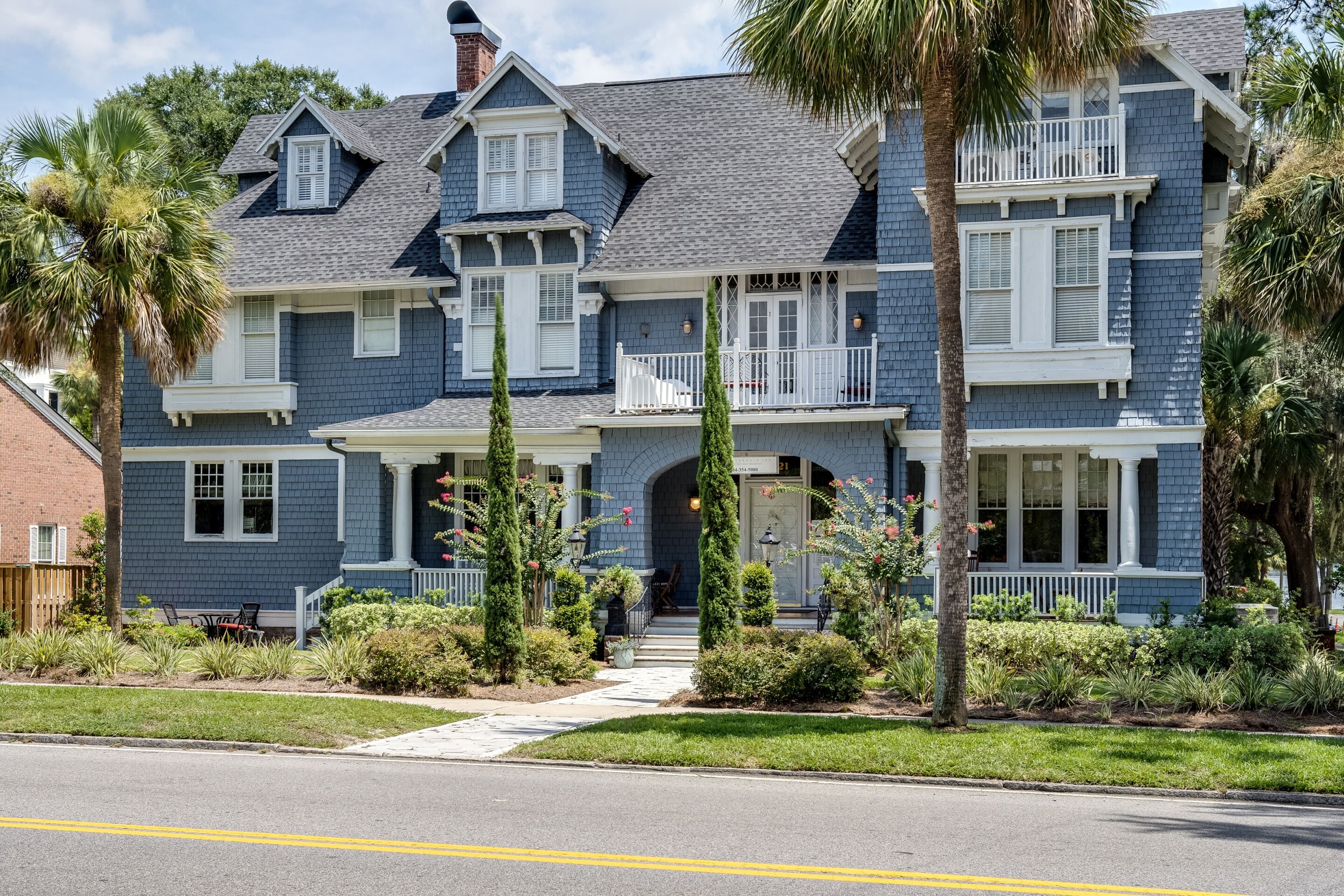 A two-story house with a porch, a garage, and a driveway.