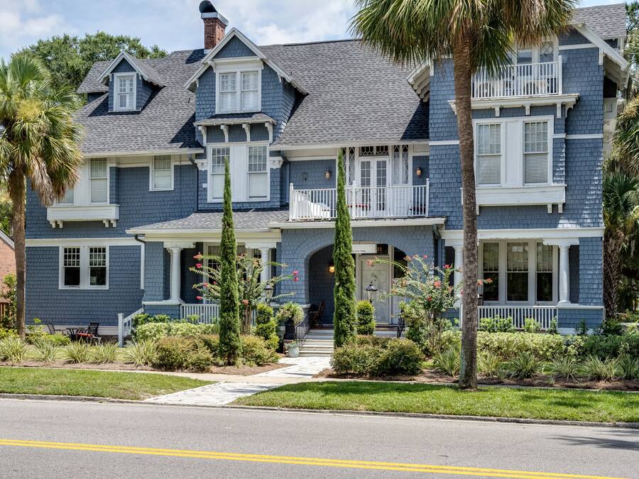 A two-story house with a porch, a garage, and a driveway.