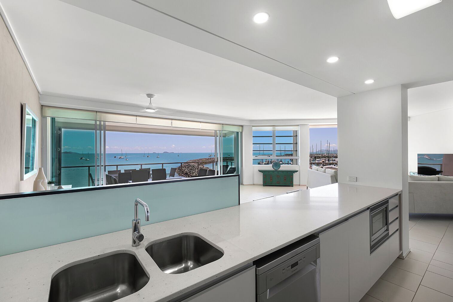 A modern kitchen with a large window overlooking a marina.