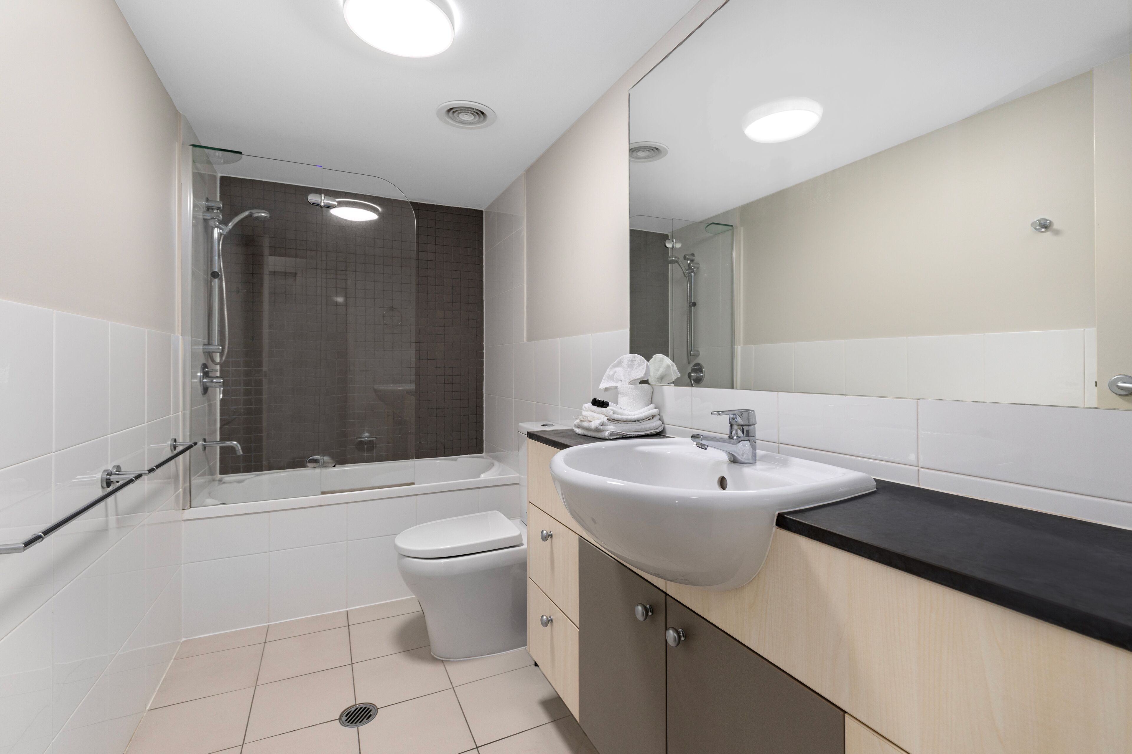 A modern bathroom with a bathtub, toilet, and sink.