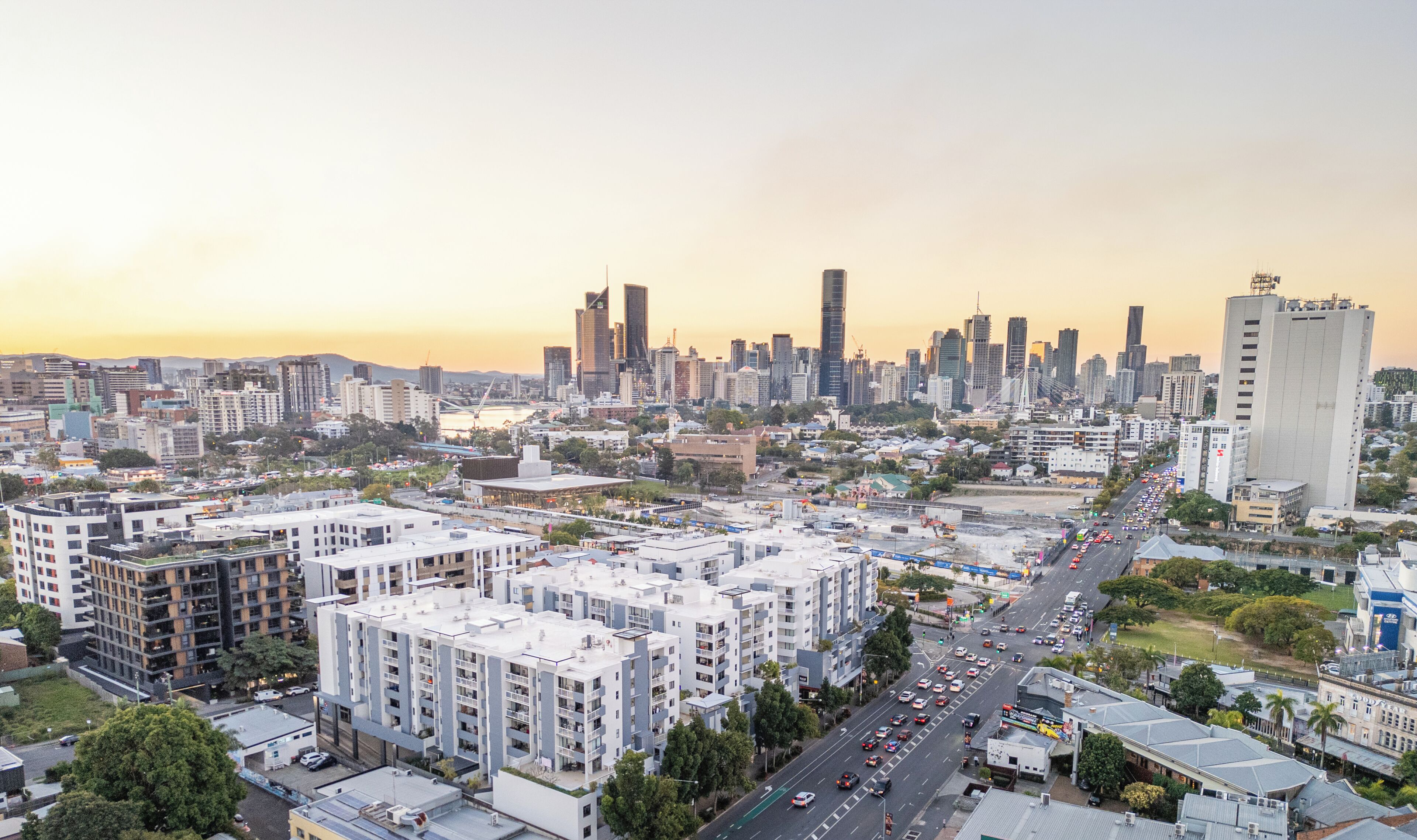 A cityscape with modern buildings, a busy street, and a clear sky.