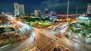 A city intersection with multiple lanes, traffic lights, and vehicles. - Gabba Central Apartments (Woolloongabba)