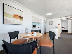 A modern kitchen with a refrigerator, microwave, and sink. - Gabba Central Apartments (Woolloongabba)