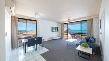 Una sala de estar moderna con balcón, comedor y sofá.