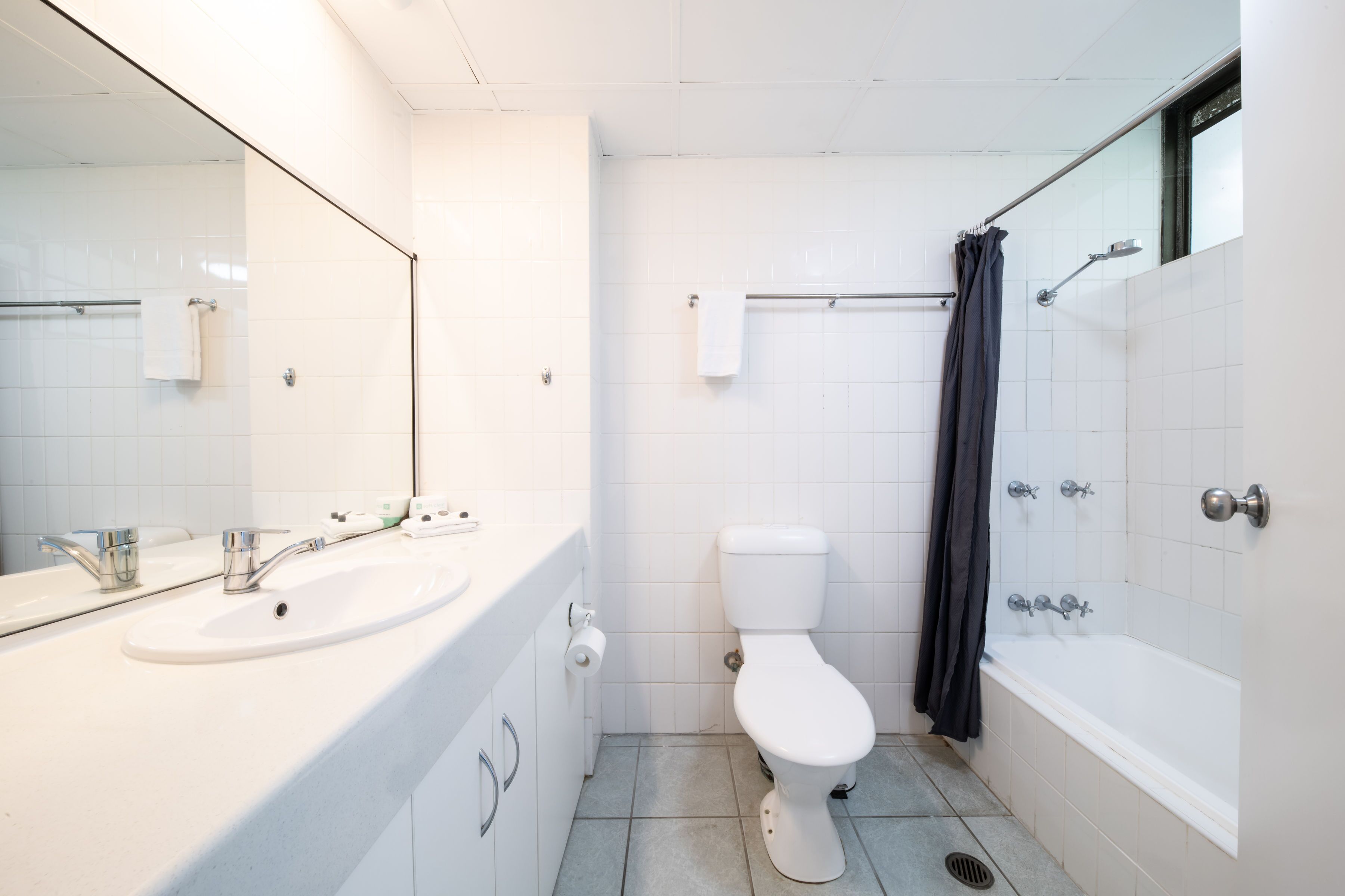 A modern bathroom with a white sink, toilet, and bathtub.