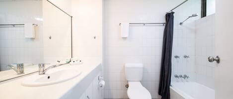 A modern bathroom with a white sink, toilet, and bathtub.