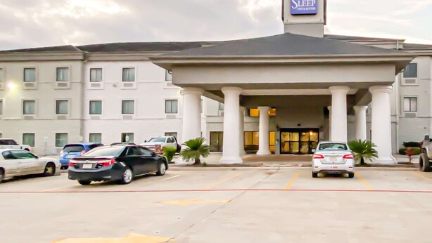 A hotel entrance with a sign reading "Sleep Their & Suites." - Sleep Inn And Suites Pearland - Houston South (Pearland)