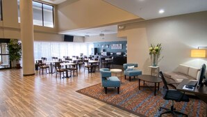 A spacious lobby with multiple seating areas, a reception desk, and a large window providing natural light. - Sleep Inn And Suites Pearland - Houston South (Pearland)