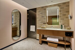 A modern bathroom with a vanity, a mirror, and a towel rack.