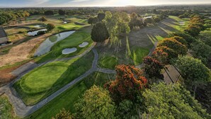 An aerial view of a golf course with multiple bunkers, water hazards, and a variety of trees. - Bicester Hotel Golf and Spa (Bicester)