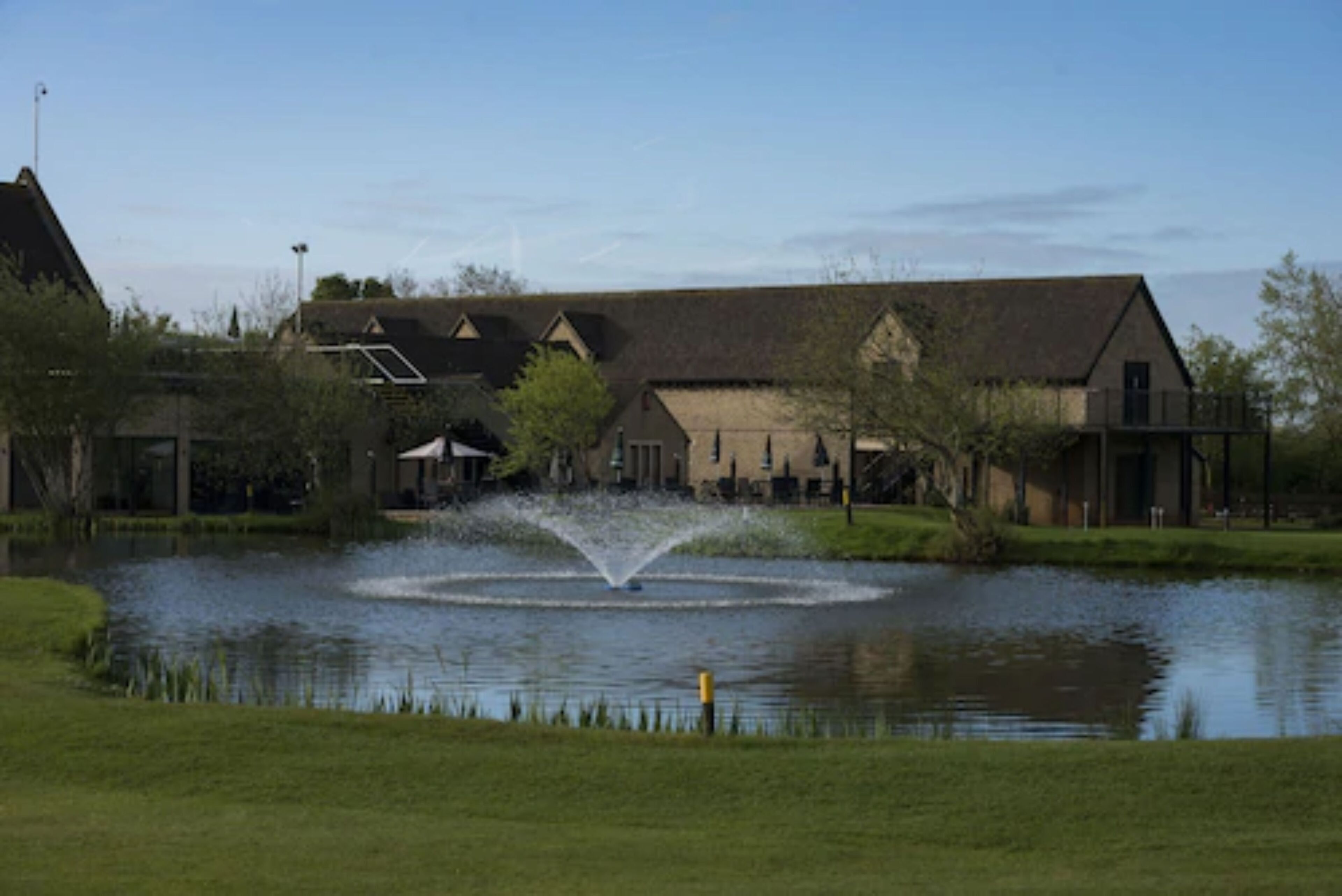 A building with a large pond and a fountain in front.
