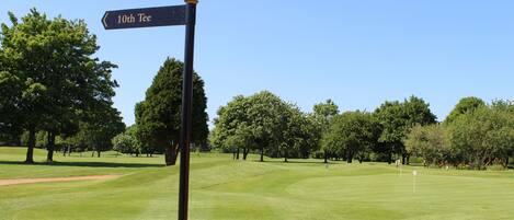 A golf course with a sign indicating the 10th tee.