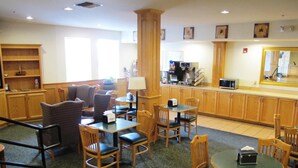 Un vestíbulo de hotel con zona de estar, estación de café y kitchenette.