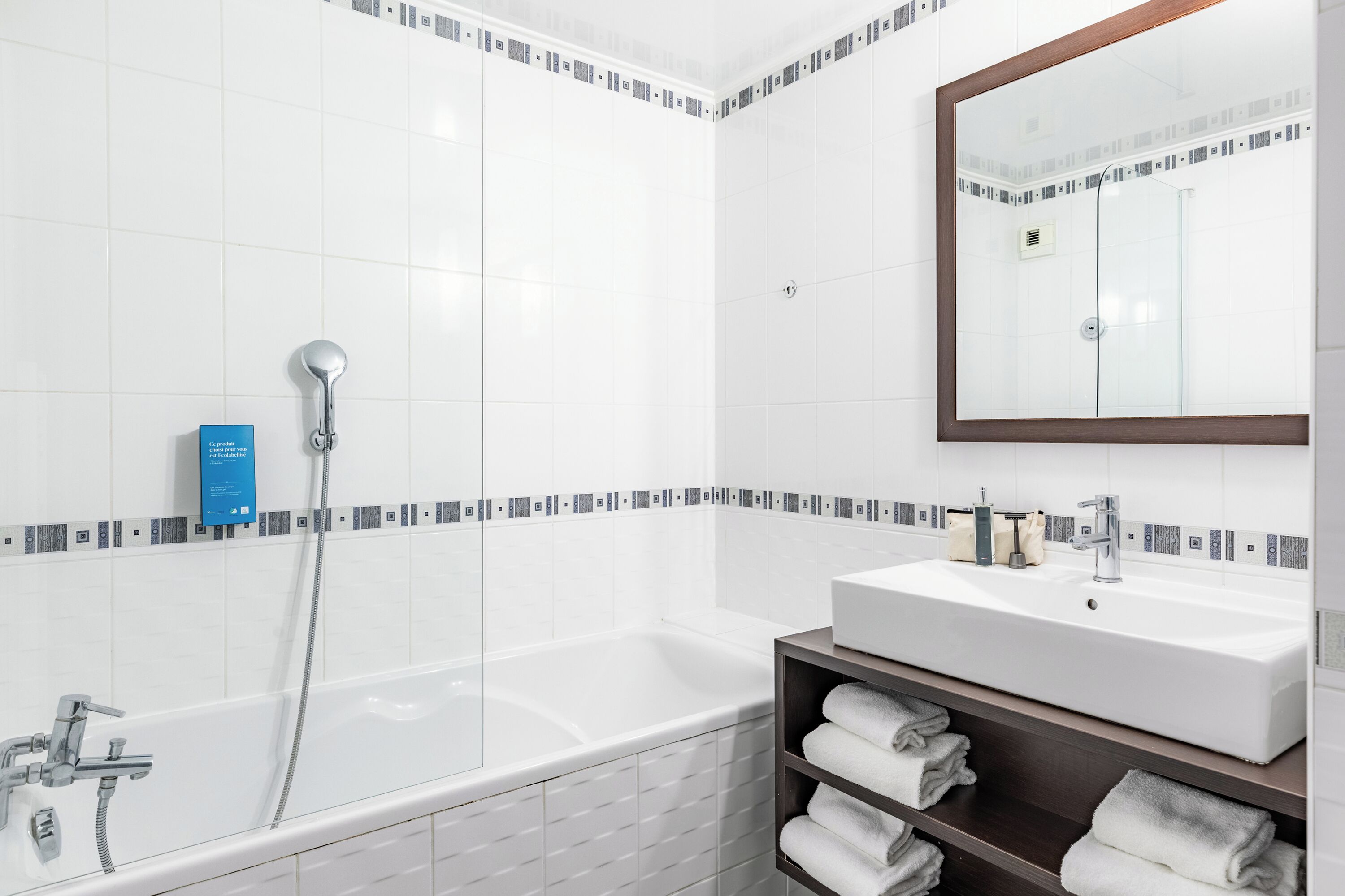 Un baño moderno con bañera, lavamanos y espejo.