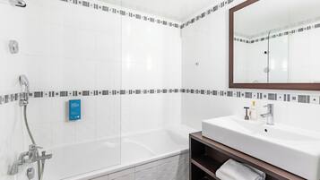 A modern bathroom with a bathtub, a sink, and a mirror.