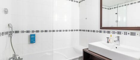 Ein modernes Badezimmer mit Badewanne, Waschbecken und Spiegel.