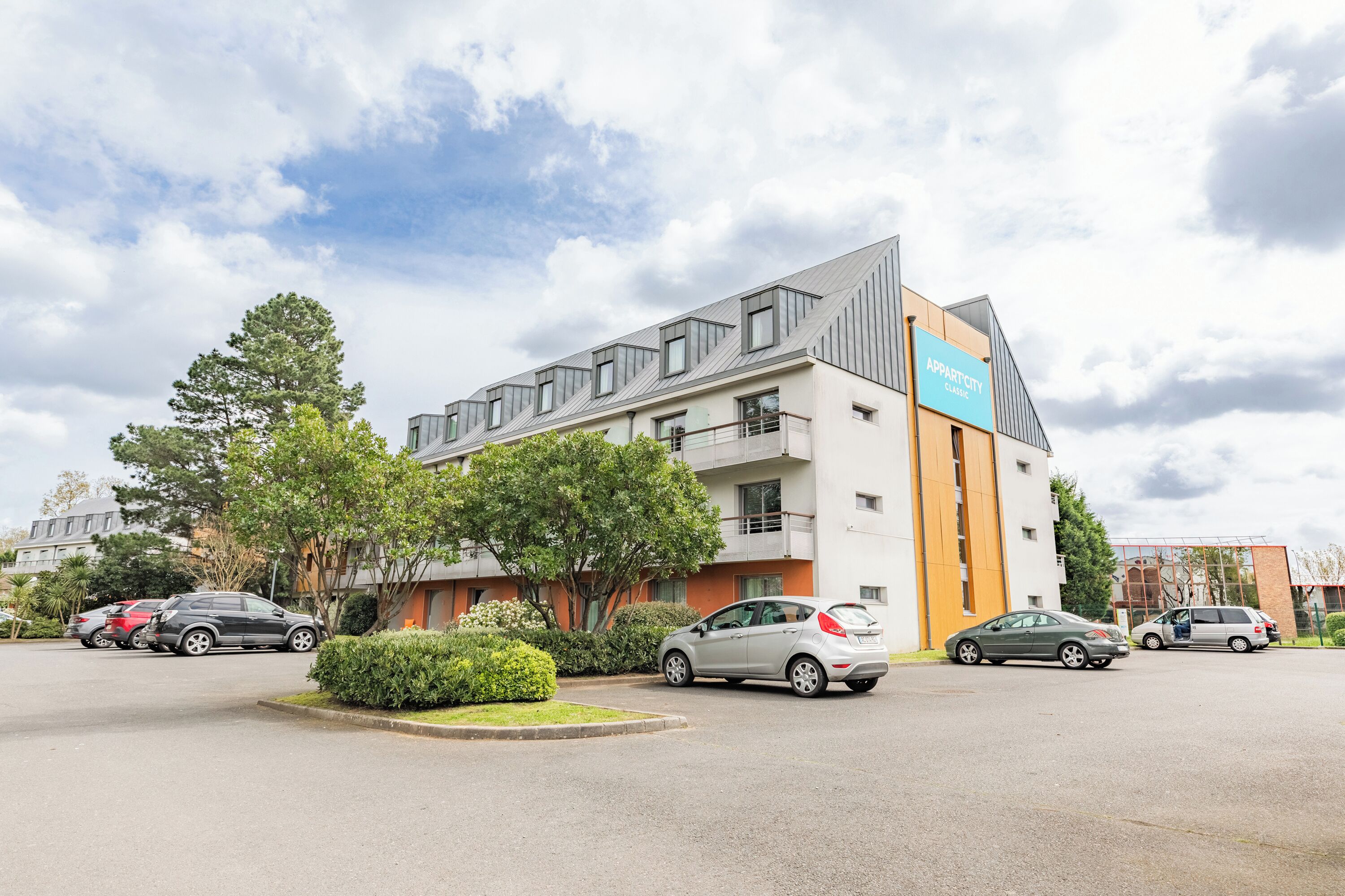 Un immeuble moderne avec une enseigne indiquant « Apartment City Club ».