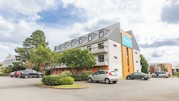 Un immeuble moderne avec une enseigne indiquant « Apartment City Club ».