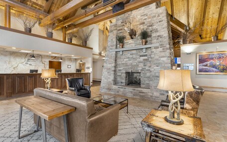 A lobby with a stone fireplace, leather seating, a reception desk, and a map on the wall.