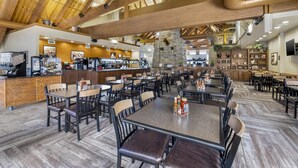 A spacious restaurant with high wooden ceilings, multiple dining tables, and a central stone feature. - Best Western Plus Bryce Canyon Grand Hotel (Bryce Canyon)