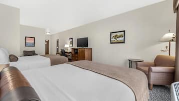 Une chambre d’hôtel avec deux lits, une télévision, un bureau, une chaise et une lampe.