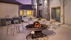 A courtyard with a fire pit, outdoor chairs, and air conditioning units. - Best Western Plus Bryce Canyon Grand Hotel (Bryce Canyon)
