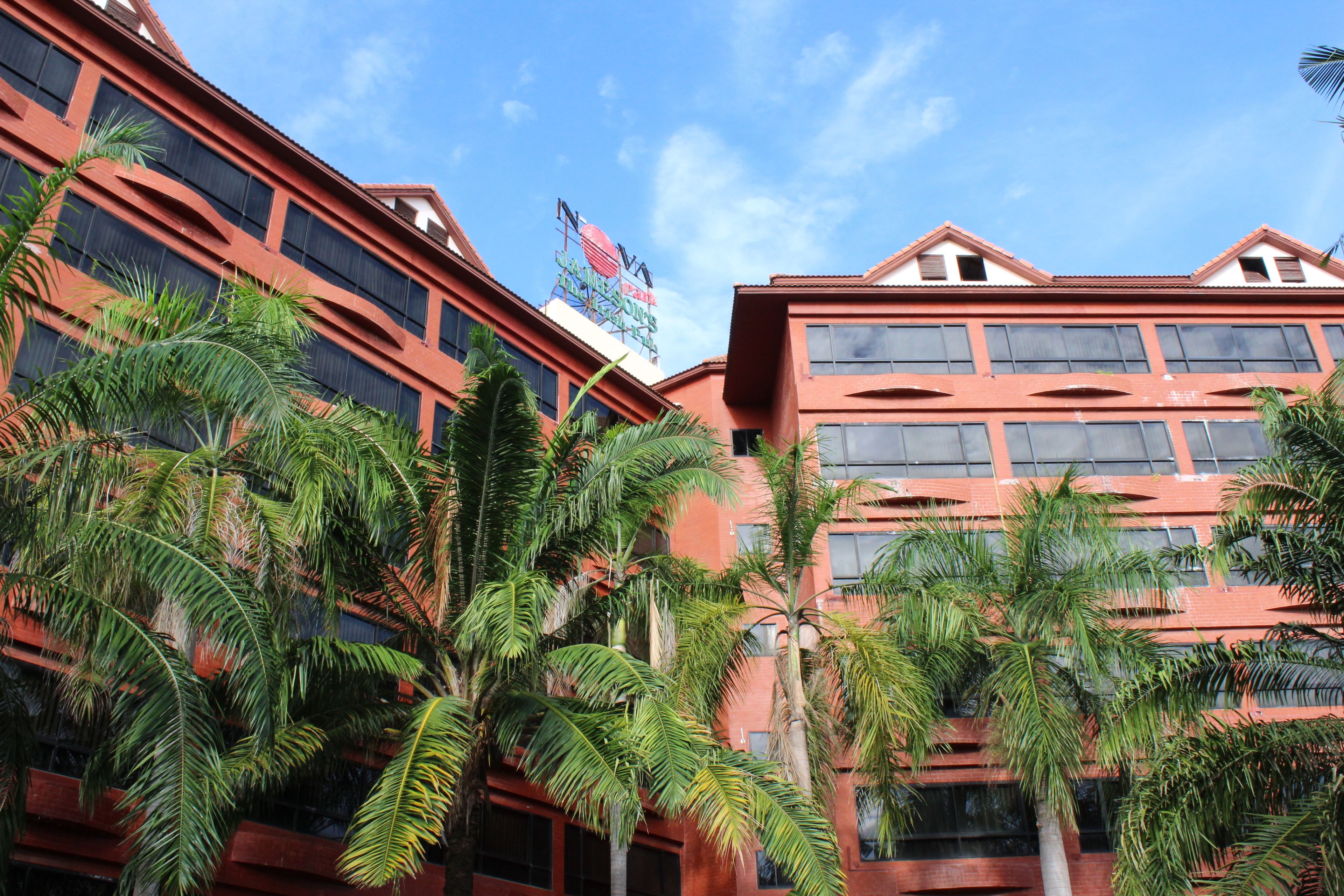 A multi-story building with a red facade and large windows.