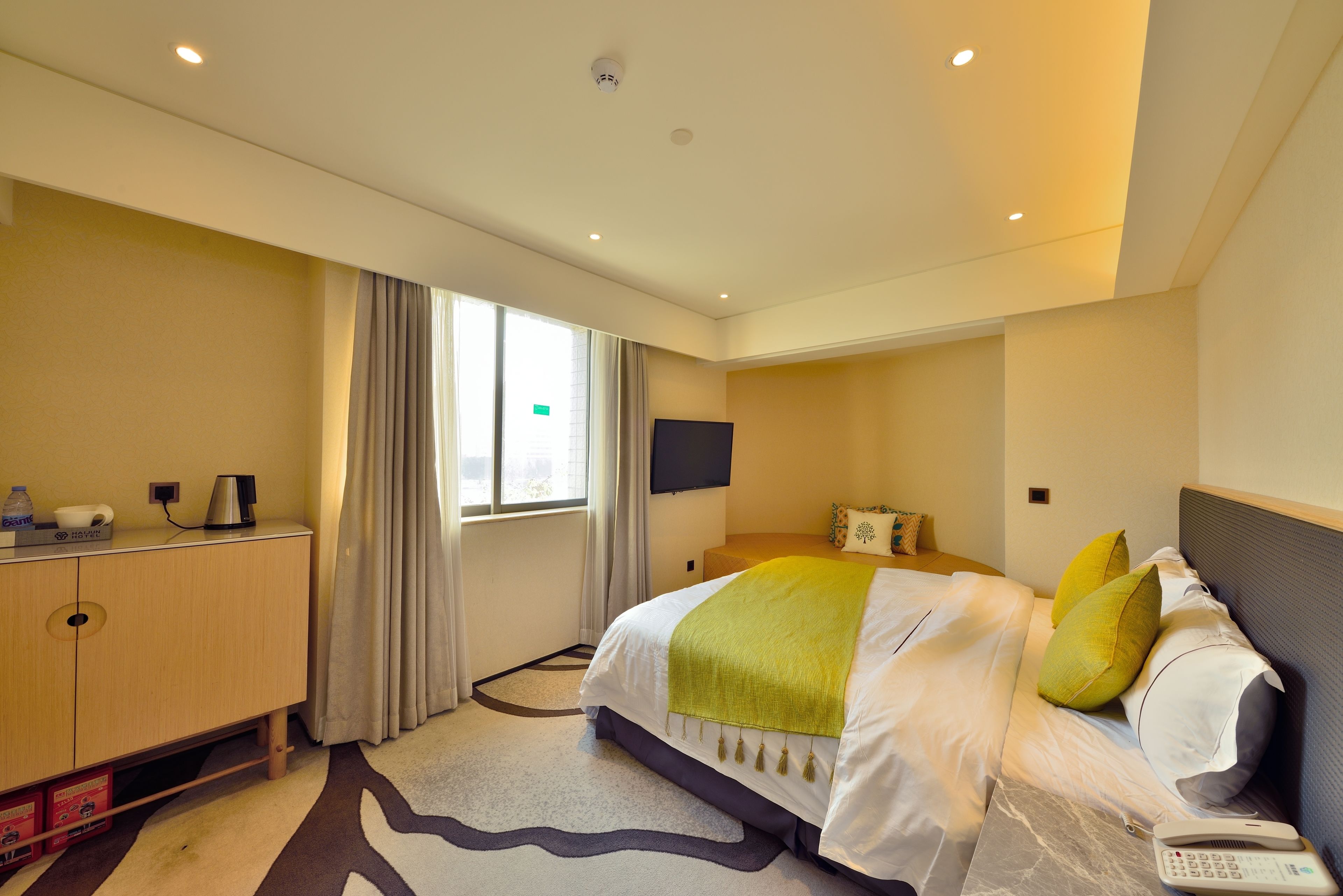 Une chambre d’hôtel équipée d’un lit, d’un bureau, d’un téléviseur à écran plat et d’une fenêtre avec des rideaux.