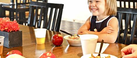 A dining table with food, drinks, and a red apple.
