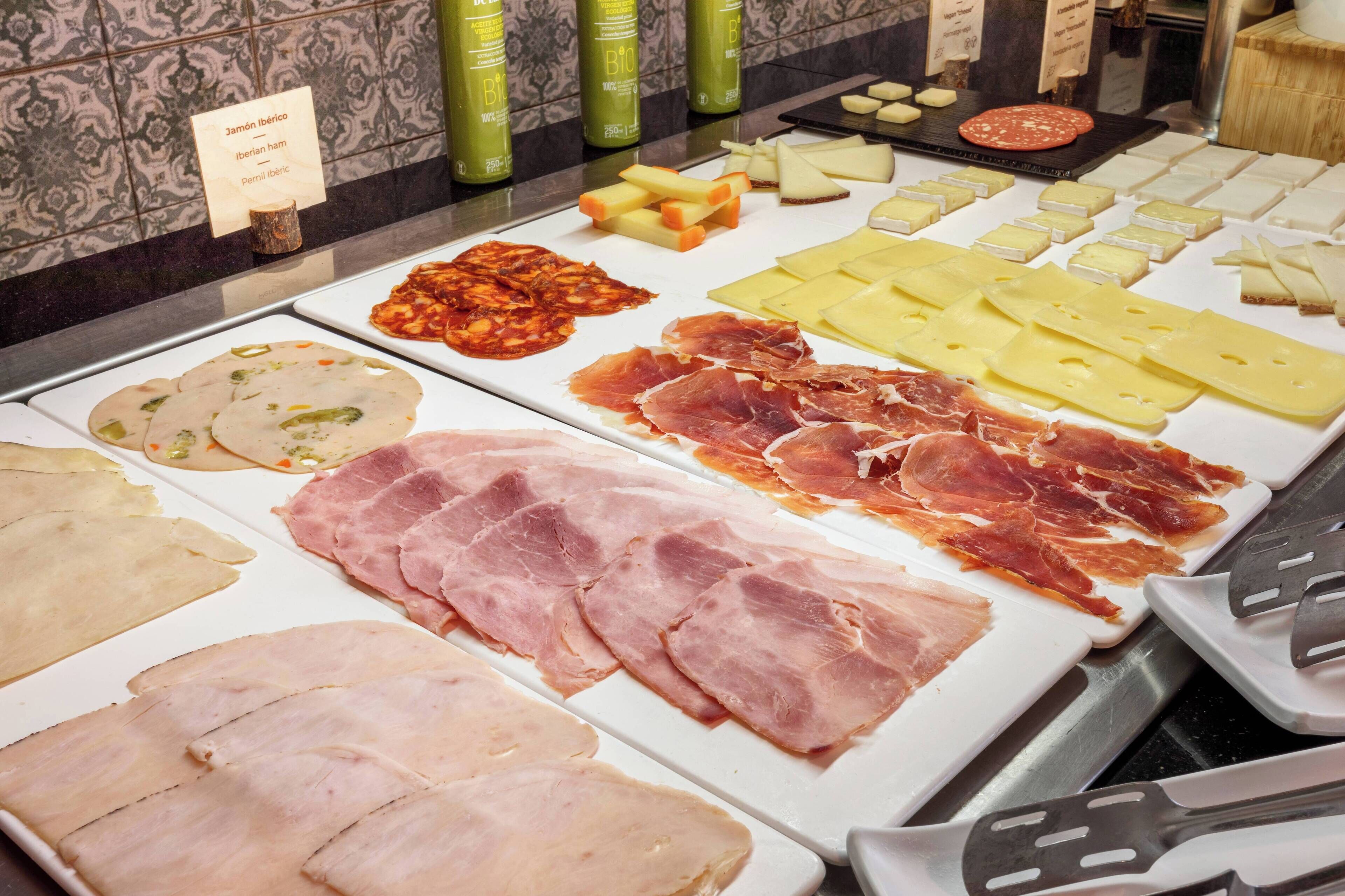 Une grande variété de viandes et de fromages sont exposés.