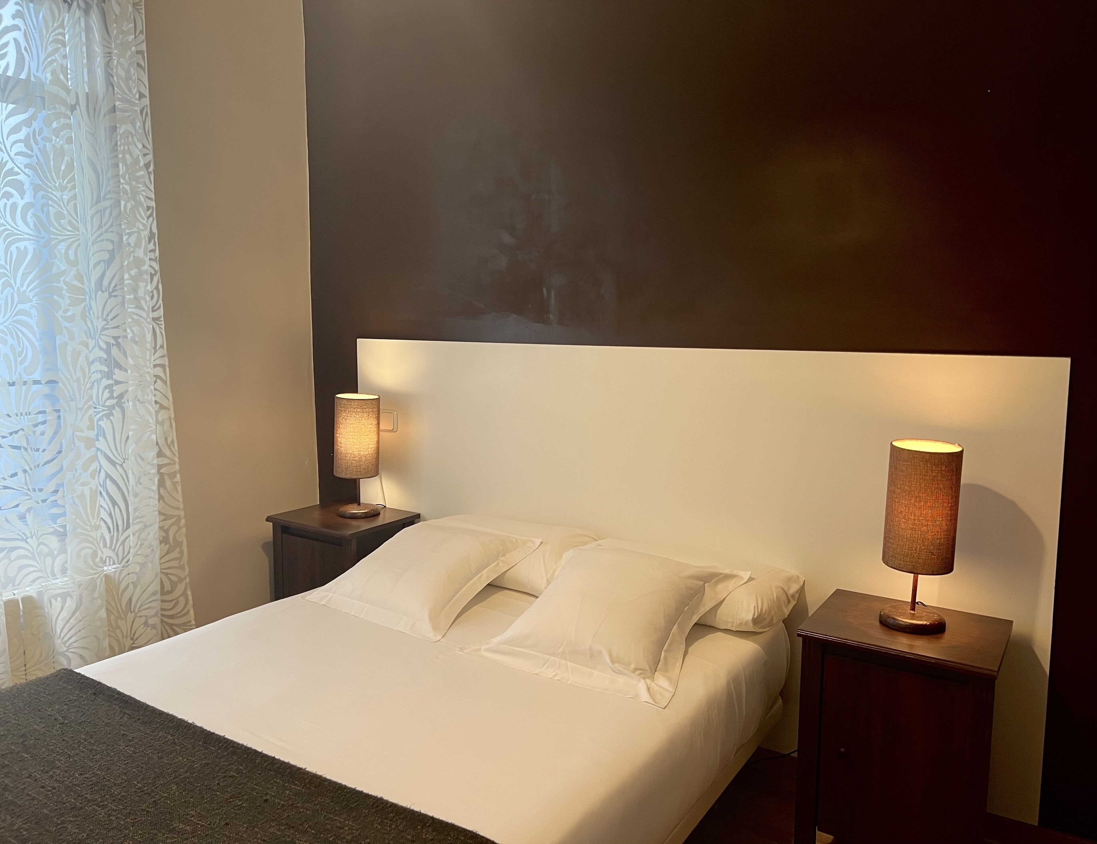 Ein Hotelzimmer mit einem großen Bett, zwei Nachttischen und einem Kopfteil.