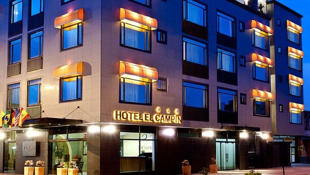 Un moderno edificio de hotel con varios pisos, grandes ventanales y un llamativo letrero que dice "HOTEL CAMPIN".